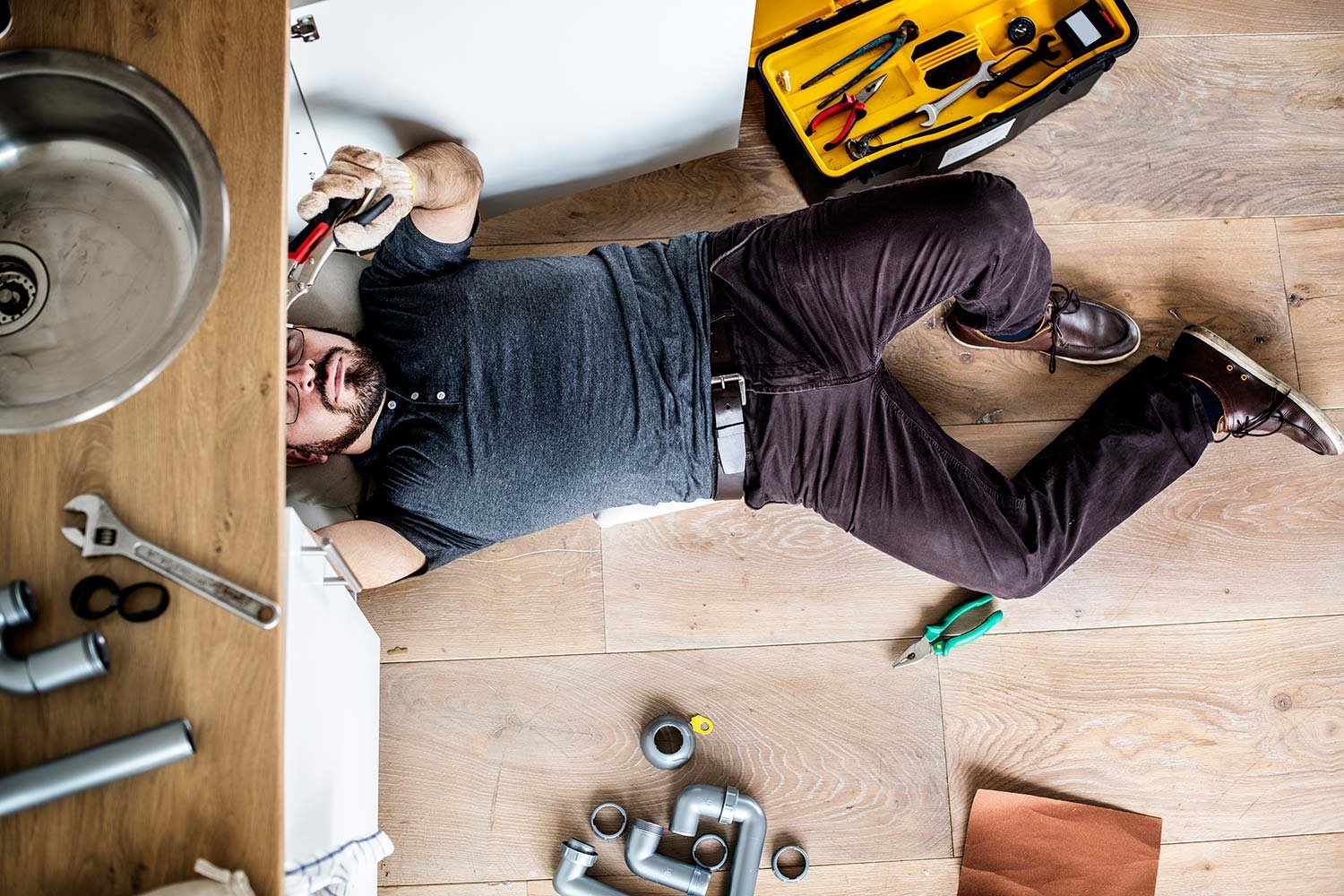 man fixing kitchen sink resize 1