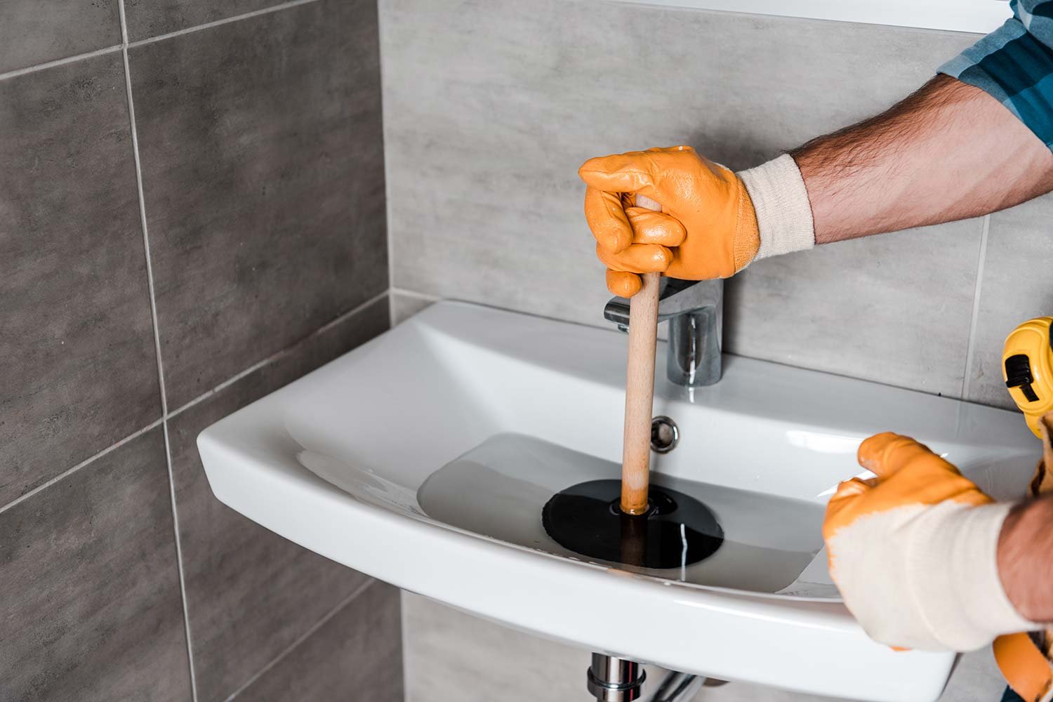 cropped view of man holding plunger in sink with w resize 1