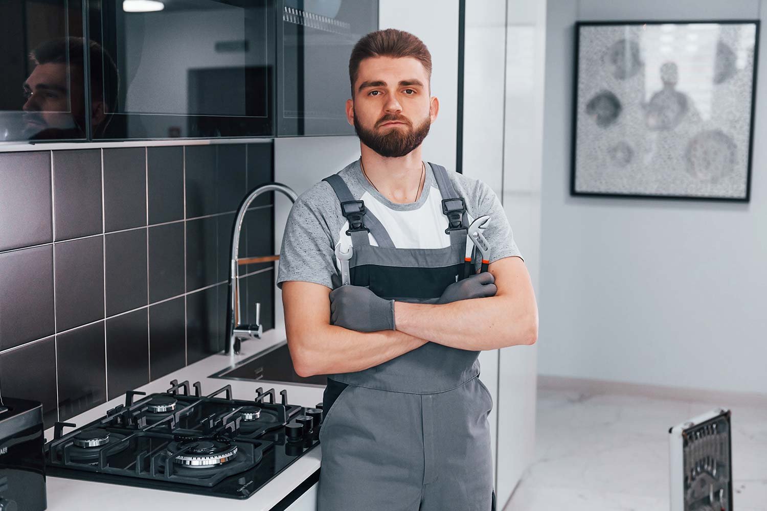 young professional plumber in grey uniform standin resize